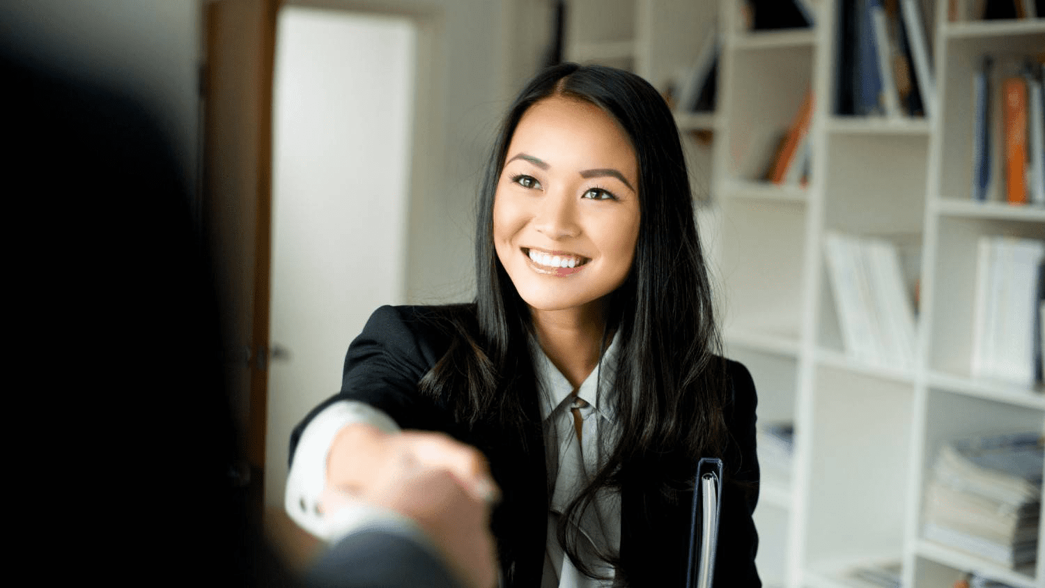 An applicant at a medical school interview shaking hands with her interviewer.